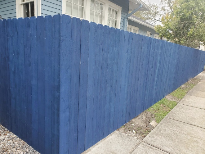Standard six-foot-high cedar fence painted blue on Audubon Street in New Orleans.