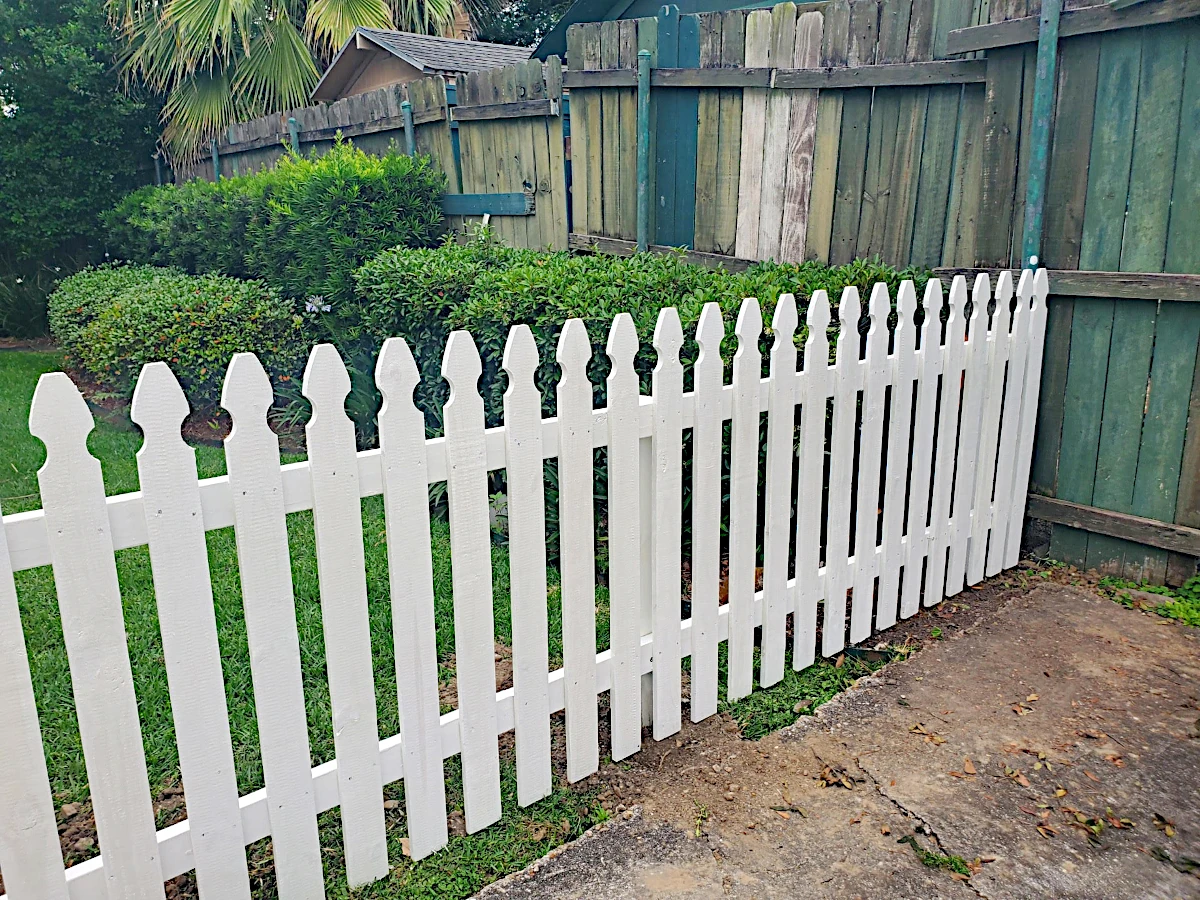 Painted white picket fence, 2 rails with one 4' wide personnel gate, 4' high. Installed in New Orleans.