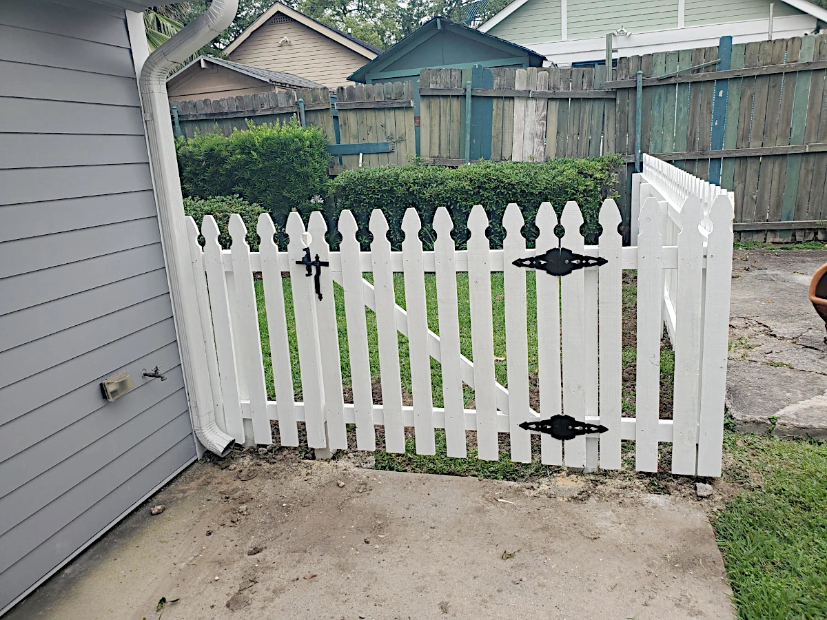 Painted white picket fence, 2 rails with one 4' wide personnel gate, 4' high. Installed in New Orleans.