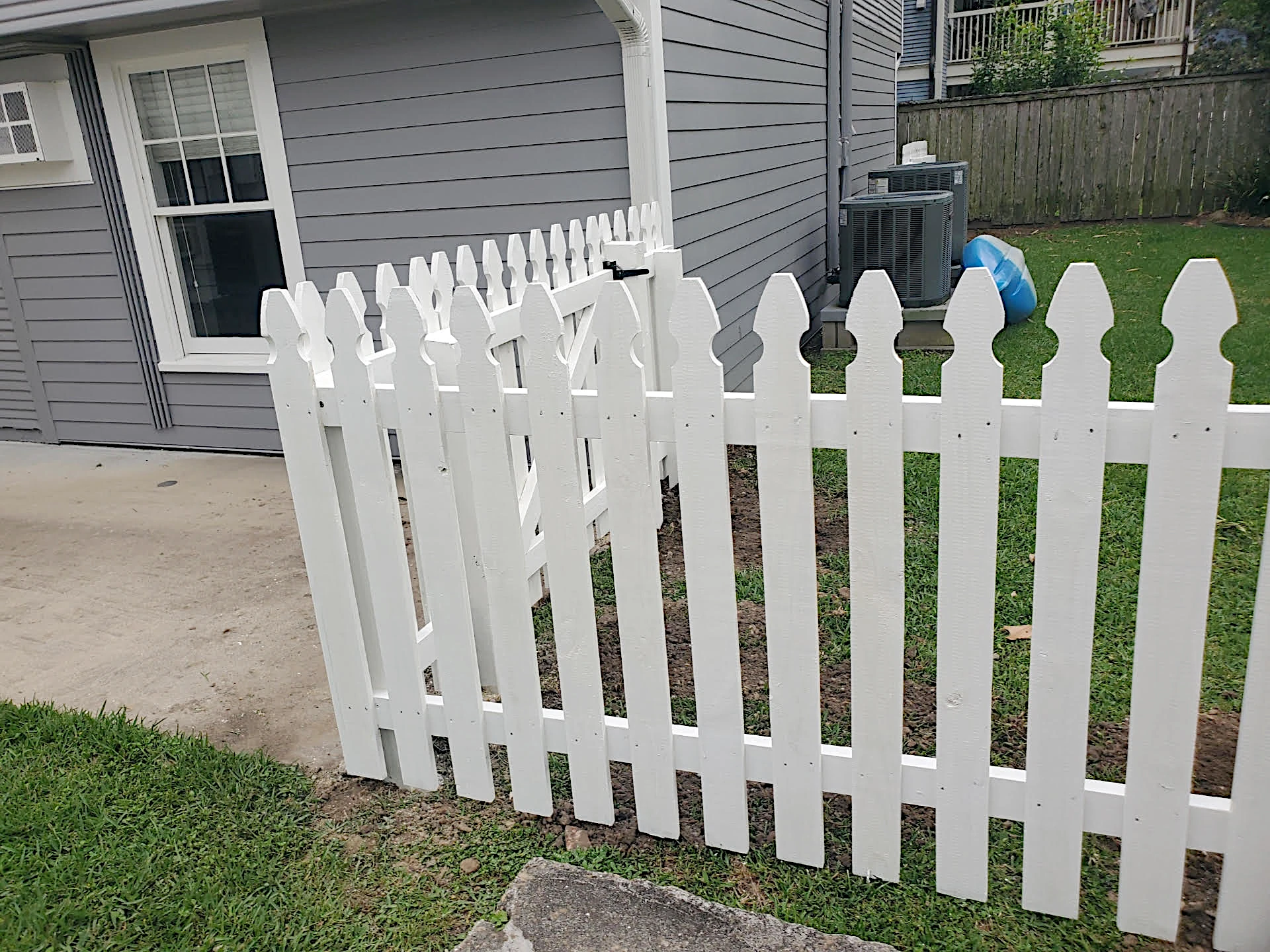 Painted white picket fence, 2 rails with one 4' wide personnel gate, 4' high. Installed in New Orleans.