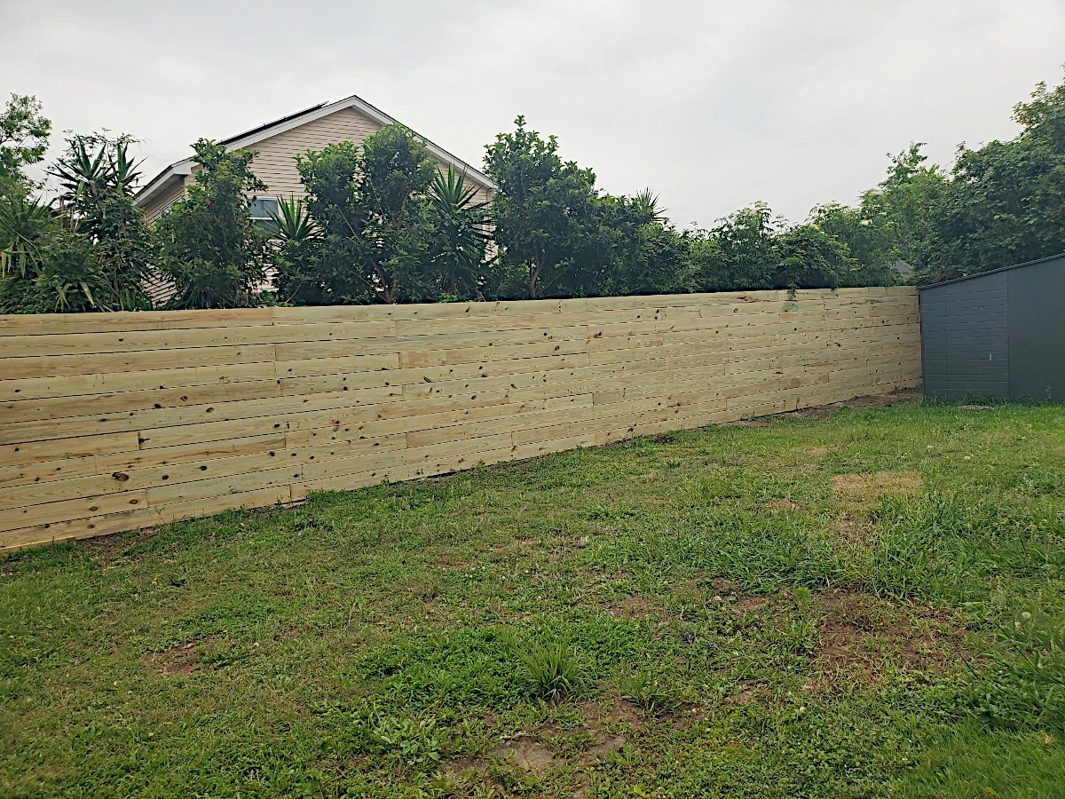 7' high pine horizontal fence using 1" x 8" planks. Planks are not feather-edged. In the Gentilly area, right by City Park.