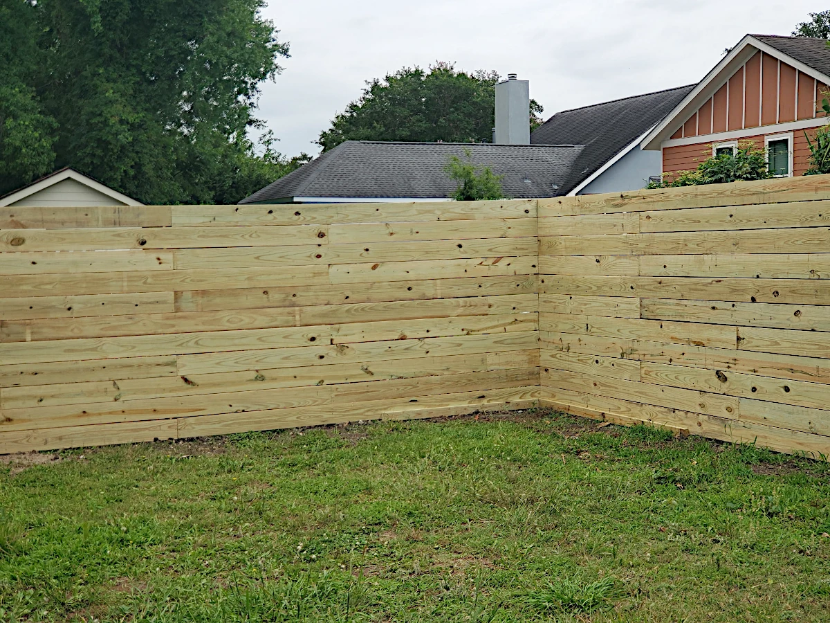 7' high pine horizontal fence using 1" x 8" planks. Planks are not feather-edged. In the Gentilly area, right by City Park.