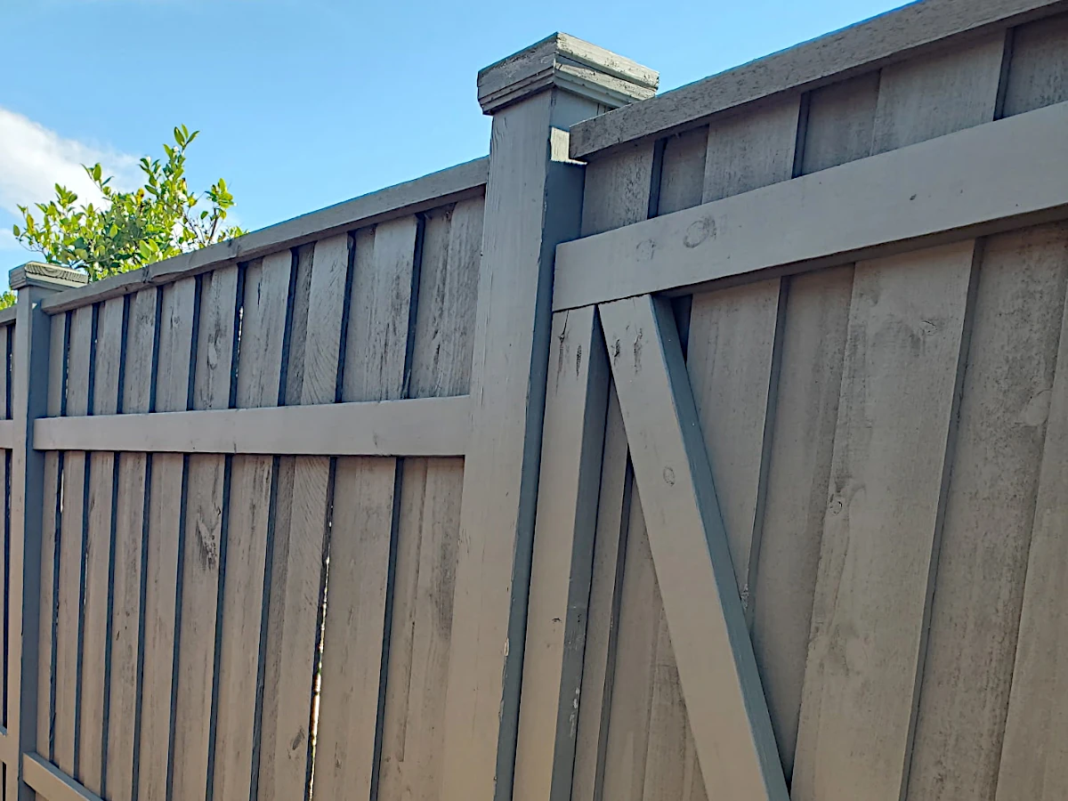 6' board-on-board pine fence in Lakeshore/Lake Vista, New Orleans — suspended between exposed 6" posts with caps, flat top cap, and 12" mudboard at the base.