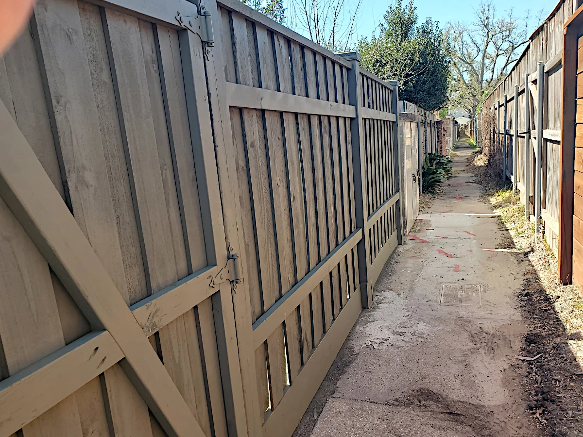 6' board-on-board pine fence in Lakeshore/Lake Vista, New Orleans — suspended between exposed 6" posts with caps, flat top cap, and 12" mudboard at the base.
