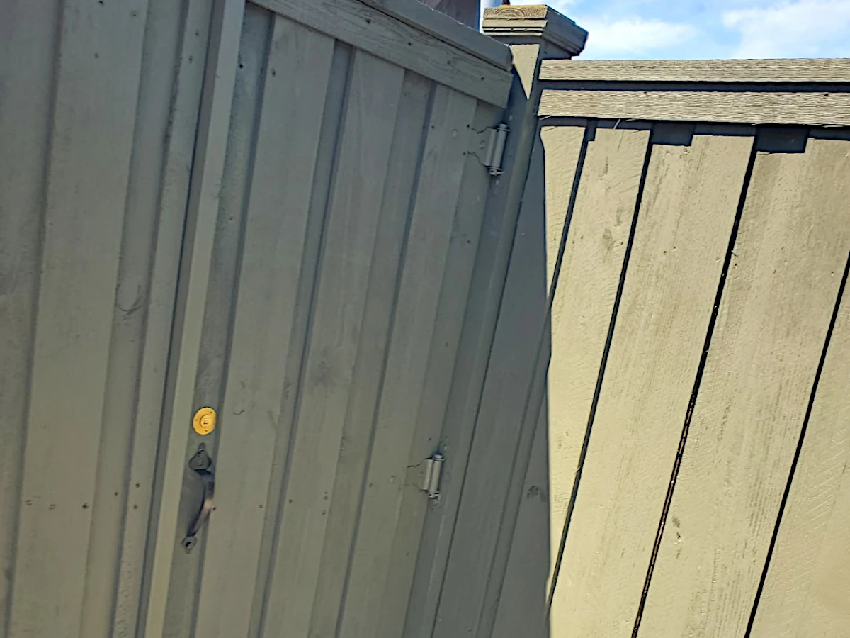 6' board-on-board pine fence in Lakeshore/Lake Vista, New Orleans — suspended between exposed 6" posts with caps, flat top cap, and 12" mudboard at the base.